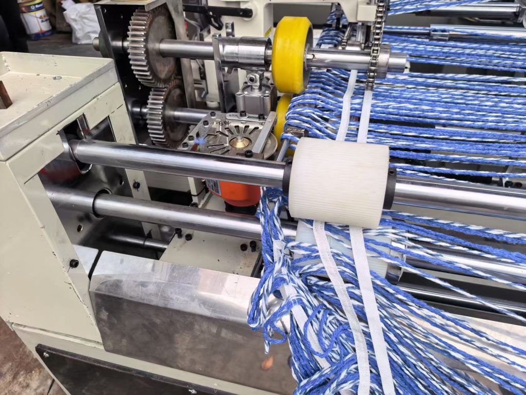Blue and white yarn running through an automatic loop mop making process