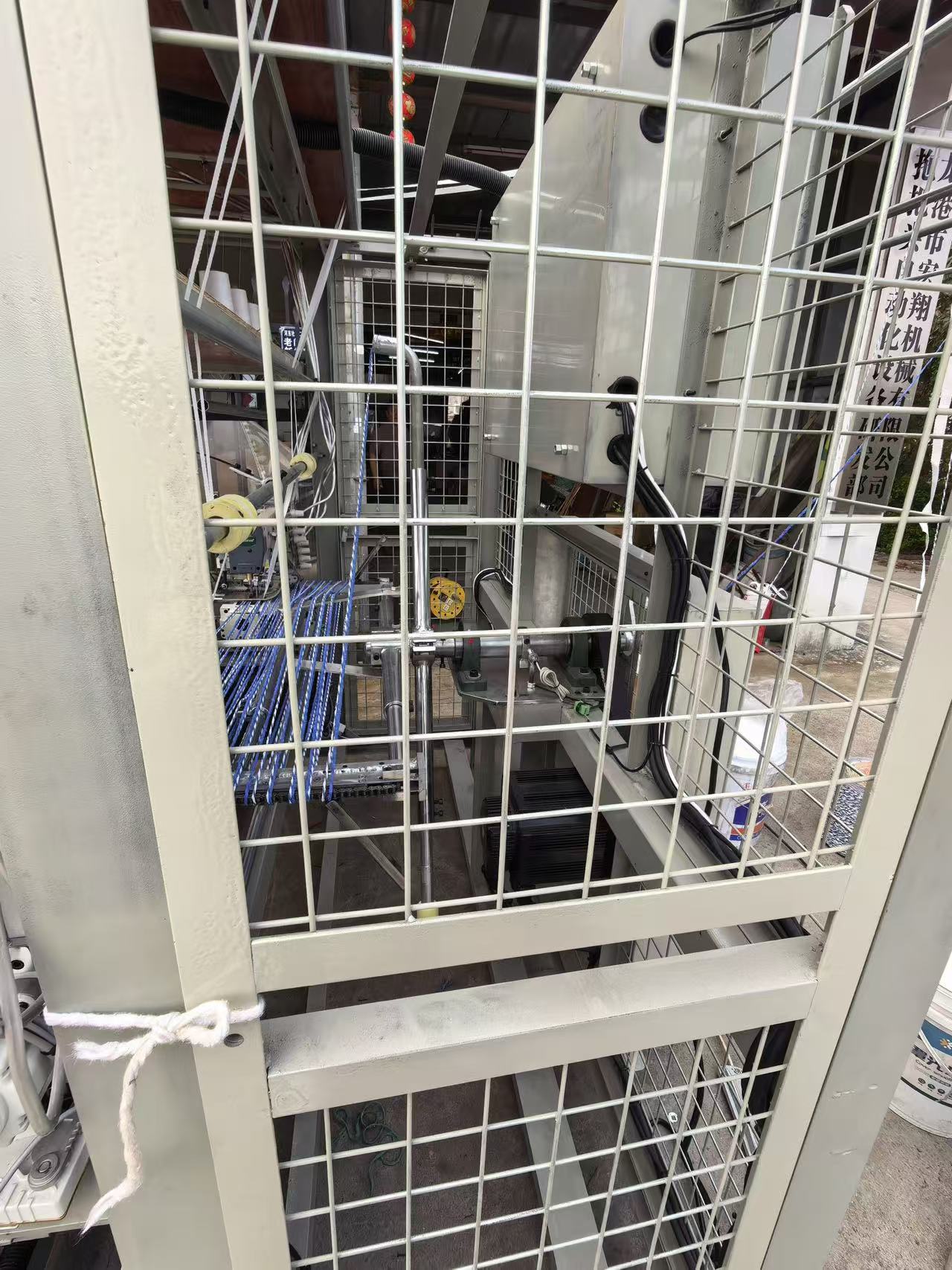 Protective net guard around an automatic loop mop making machine