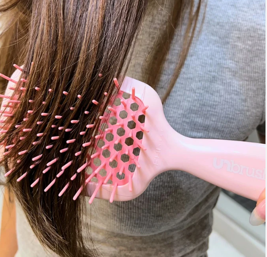 Pink flexible vent detangling brush used on long hair